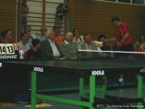 Milan Orlowsky bietet Wilhelm Krieger den Tischtennisschläger an